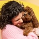 A Woman hugging a brown dog