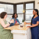 Three women around a kitchen island talking