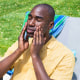 Man rubbing sunscreen on his face outdoors