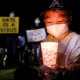 Lael Choi holds a candle during a vigil in solidarity with the Asian American and Pacific Islander communities at Almansor Park in Alhambra, Calif., on March 20, 2021.