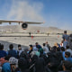 Afghans wait to leave the airport in Kabul on Aug. 16, 2021.