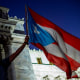 A demonstrator waves a flag in front of Puerto Rico's Capitol during a protest against Puerto Rico Governor Wanda Vazquez and the government in San Juan on Jan. 20, 2020.