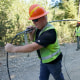 Carl Roath, left, a worker with the Mason County (Wash.) Public Utility District, pulls fiber optic cable off of a spool, as he works with a team to install broadband internet service to homes in a rural area surrounding Lake Christine near Belfair, Wash., Aug. 4, 2021.