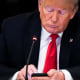 Former President Donald Trump works on his phone during a roundtable at the State Dining Room of the White House on June 18, 2020.