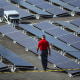 A man walks between solar panels at the San Juan Children's Hospital on Oct. 26, 2017, in San Juan, Puerto Rico.