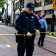 A police officer ties barricade tape at the crime scene after an early-morning shooting in a stretch of downtown near the Golden 1 Center arena in Sacramento, Calif., on April 3, 2022.