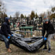 Workers line up bodies for identification by forensic personnel at a cemetery in Bucha, Ukraine, on April 6, 2022.