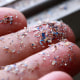 Close up side shot of microplastics lay on people hand.