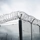 Chain link fence with barbed wire and razor wire.