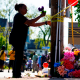 A person tends to a makeshift memorial outside of Tops Friendly Market, in Buffalo, N.Y., on May 15, 2022.