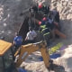 Rescue crews try to free two teenagers from a 10-foot hole in the beach that collapsed on them Tuesday in Toms River, N.J.