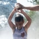 Samio, 8, and his father, pour water on each other to cool off while playing in cooling mist near the Unisphere in Flushing Meadows Corona Park as temperatures reach above 90 degrees on Aug. 12, 2021 in Queens, N.Y.