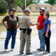 A policeman talks to people asking for information outside of the Robb Elementary School