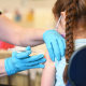 A nurse administers the Covid-19 vaccine to a girl