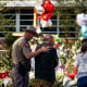Image: A man is comforted by a Texas Department of Public Safety officer at a memorial outside Robb Elementary School created to honor the victims killed in last week's school shooting, on June 3, 2022, in Uvalde, Texas.