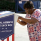 A voter drops their ballot off during early voting in Athens, Ga., on Oct. 19, 2020.