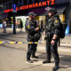 Police stand guard outside a bar in central Oslo early Saturday after two people were killed and more than a dozen injured in a shooting.