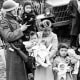 Image: Cpl. George Bushy, left, a member of the military guard  holds the youngest child of Shigeko Kitamoto, center,  on March 30, 1942 as she and her children are evacuated from Bainbridge Island, Wash.