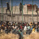 Policías antimotines acordonan la zona después que migrantes arriban a suelo español y saltan las cercas que separan el enclave español de Melilla de Marruecos, en Melilla, España, viernes 24 de junio de 2022.