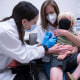 Pharmacist Kaitlin Harring, left, administers a Moderna COVID-19 vaccination to three year-old Fletcher Pack, while he sits on the lap of his mother, McKenzie Pack, at Walgreens pharmacy Monday, June 20, 2022, in Lexington, S.C. Today marked the first day COVID-19 vaccinations were made available to children under 5 in the United States. (AP Photo/Sean Rayford)