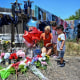 People visit a memorial on June 29, 2022 at the spot where a trailer was discovered with migrants inside