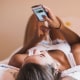 Teenage girls lying on bed looking at smart phones