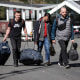 Image: Russian men carry their luggage after crossing the border at Verkhny Lars between Georgia and Russia