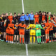 Image: Portland Thorns and Houston Dash players, along with referees, gather at midfield, in demonstration of solidarity with two former NWSL players who came forward with allegations of sexual harassment and misconduct