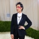  Eugene Lee Yang at the Met Gala, dressed in a suit and wearing expressive makeup.