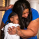 George Floyd's daughter Gianna Floyd gives her mother Roxie Washington a hug during a press conference
