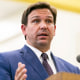 on May 4, 2021 file photo shows Florida Gov. Ron DeSantis, center, speaks during a news conference at West Miami Middle School in Miami.  Several states scaled back their reporting of COVID-19 statistics this July 2021, just as cases across the country started to skyrocket, depriving the public of real-time information on outbreaks, cases, hospitalizations and deaths in their communities.