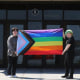 Former Viking Saga newspaper staff members Marcus Pennell, left, and Emma Smith display a pride flag outside of Northwest High School in Grand Island