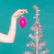 Image: Woman putting Christmas decoration on artificial, silver tree