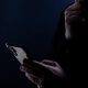 Silhouette of a man using a mobile phone in the dark