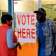 Voters exit a polling station at the National Guard Military Base during the presidential primary in Camden, Ala.,