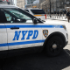 Pedestrians walk past a NYPD vehicle parked in front of One World Trade