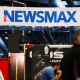 Signage for the Newsmax conservative television broadcasting network is displayed at a broadcast TV booth at the National Rifle Association (NRA) annual meeting at the George R. Brown Convention Center, in Houston, Texas on May 28, 2022. 