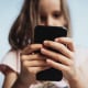 Close-up of girl using mobile phone outdoors