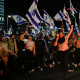 Israelis opposed to Prime Minister Benjamin Netanyahu's judicial overhaul plan block a highway during a protest moments after the Israeli leader fired his defense minister, in Tel Aviv, Israel, Sunday, 