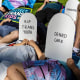 Protesters lie on the ground holding cardboard signs shaped like tombstones in front of the Marriott Fort Lauderdale Airport as the Florida Board of Medicine meets inside.