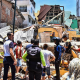 Image: Residents and rescue workers stand in front of buildings brought down by an earthquake that shook Machala, Ecuador, on March 18, 2023.