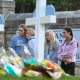 Students at a nearby school pay respects at a memorial for victims at an entry to Covenant School