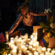 A migrant girl lights a candle during a vigil for the victims of a fire at an immigration detention center that killed at least 40 people, in Ciudad Juarez, Mexico, on March 28, 2023.
