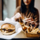 Una pareja come una hamburguesa en un restaurante.
