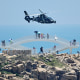 Tourists look on as a Chinese military helicopter flies past China's Pingtan Island, the closest point to Taiwan, on Aug. 4, 2022, ahead of massive military drills.