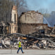 A worker walks past the rubble of an industrial fire that continued to burn in Richmond, Ind.