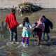 Migrants cross the Rio Grande into El Paso, Texas, on Jan. 8, 2023, from Ciudad Juarez, Mexico.