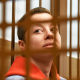 Yevgenia Berkovich sits in a cell at court in Moscow