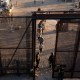 Migrants walk through a gate to surrender to Customs and Border Protection agents for immigration and asylum claim processing