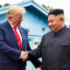 Donald Trump shakes hands with Kim Jong Un